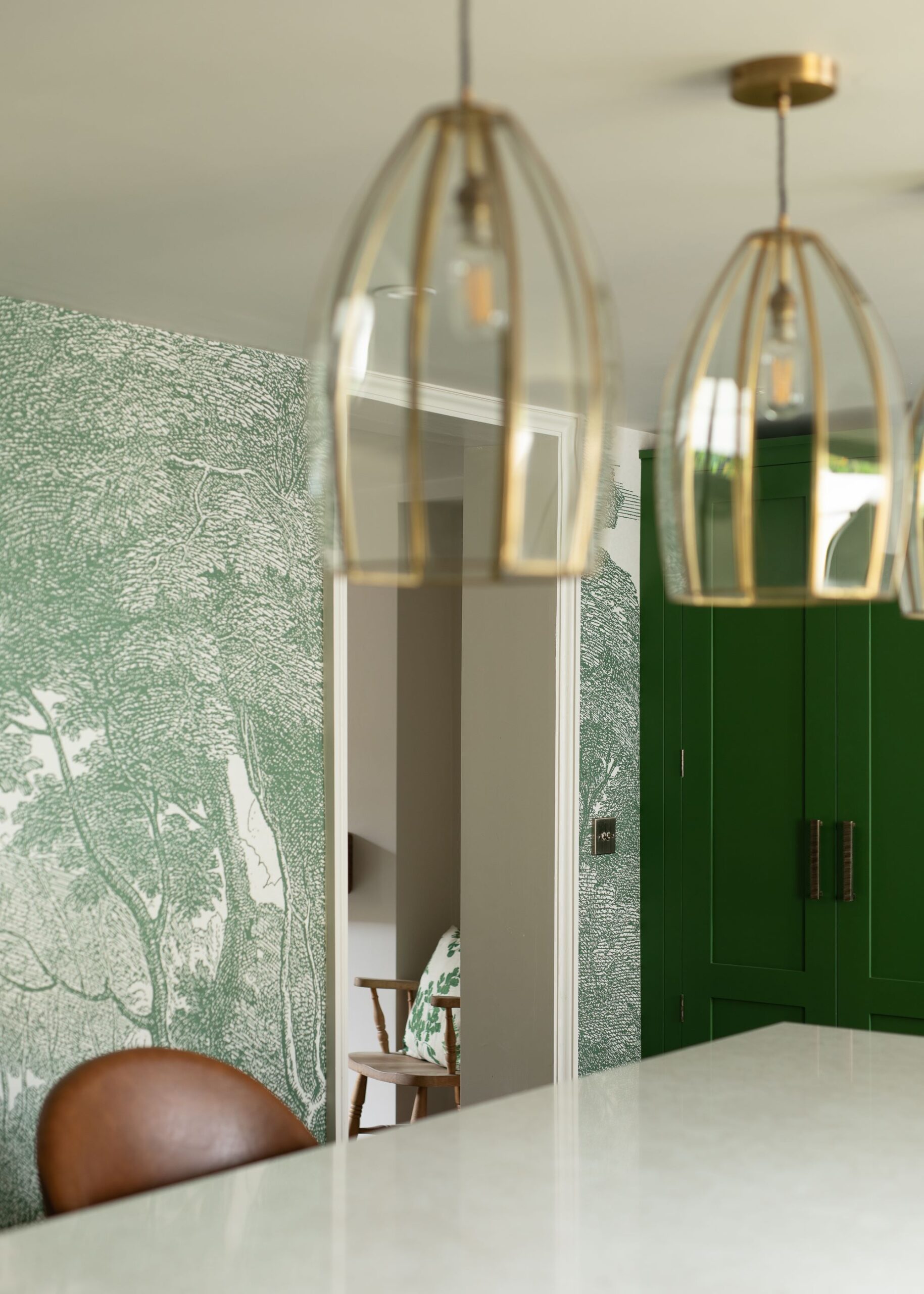 Green kitchen colour palette with green cabinetry and wallpaper accent wall