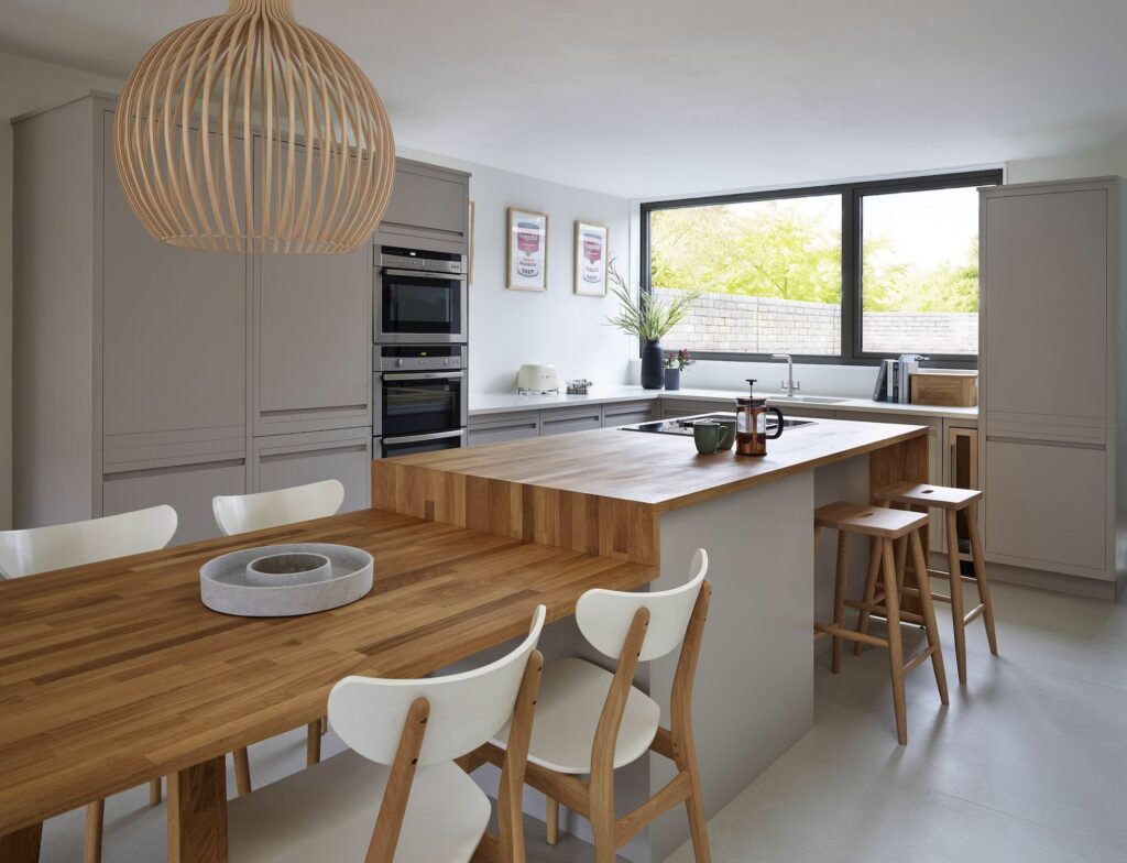 Smart kitchen diner idea for a smaller space with wooden waterfall countertops and island seating