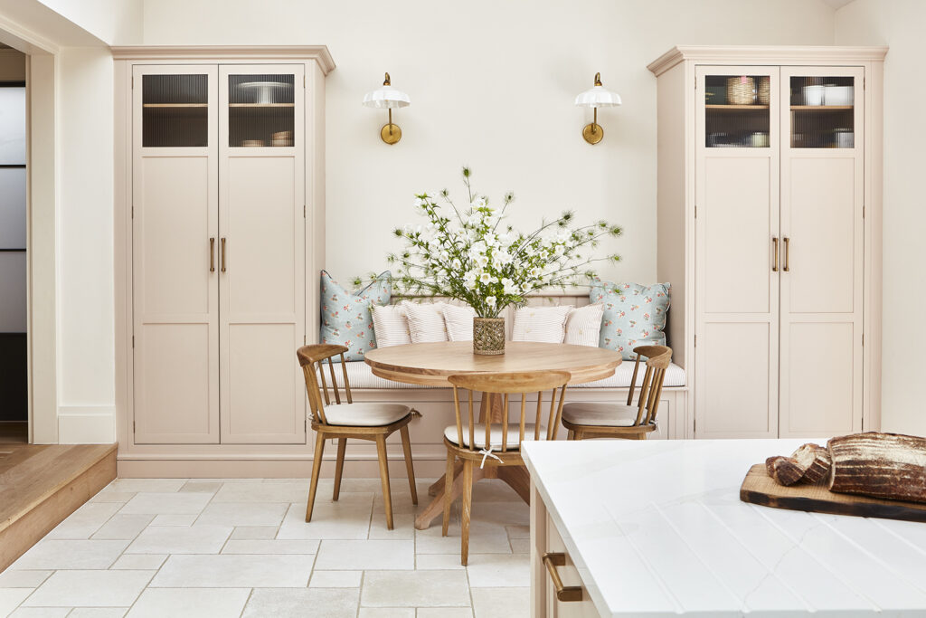 Pink kitchen diner with bright decor and banquette seating