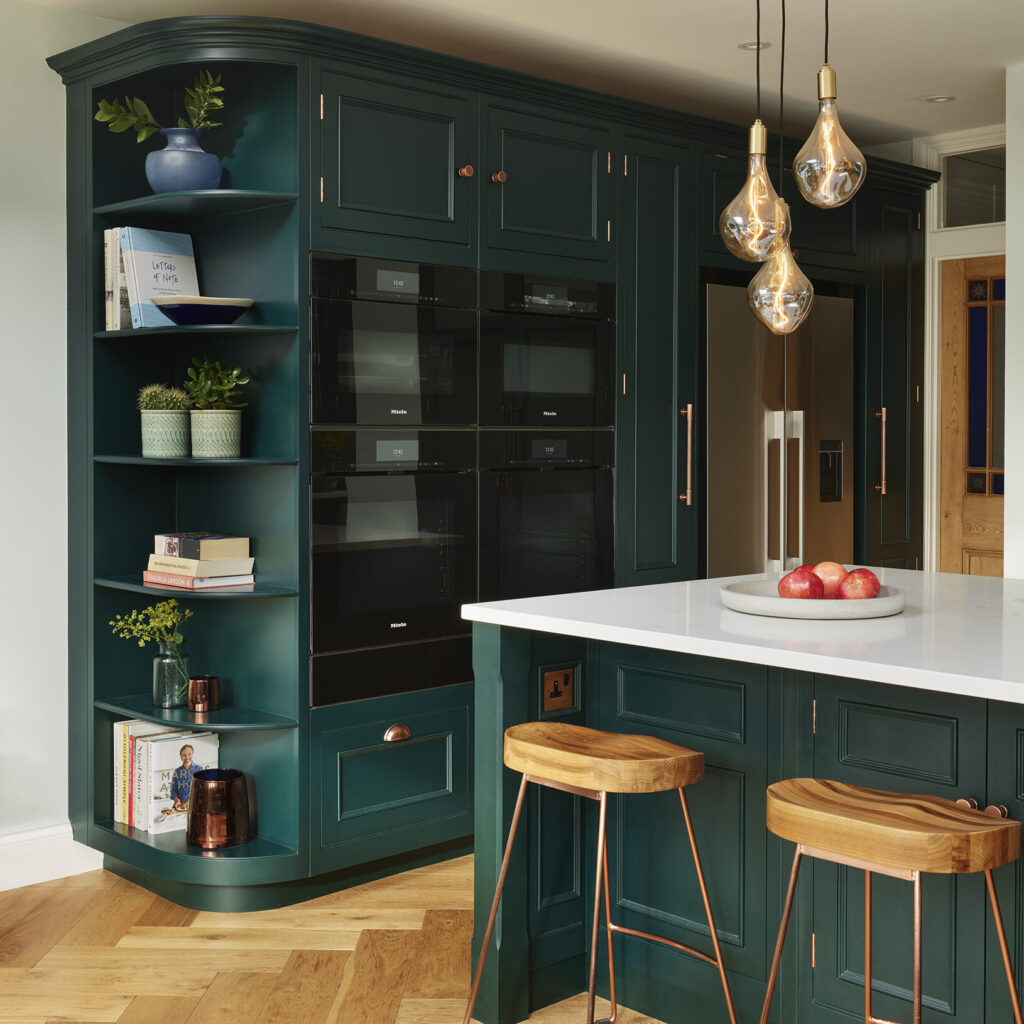 Dark green kitchen with handleless integrated double ovens