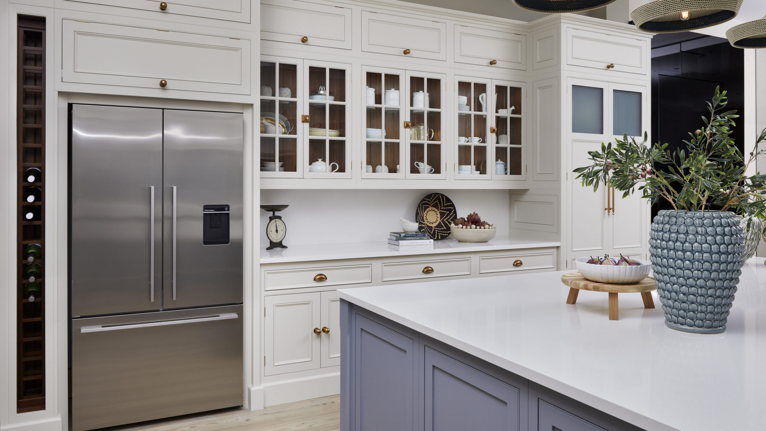 stainless steel american style fridge freezer nestled into white cabinetry in a premium kitchen