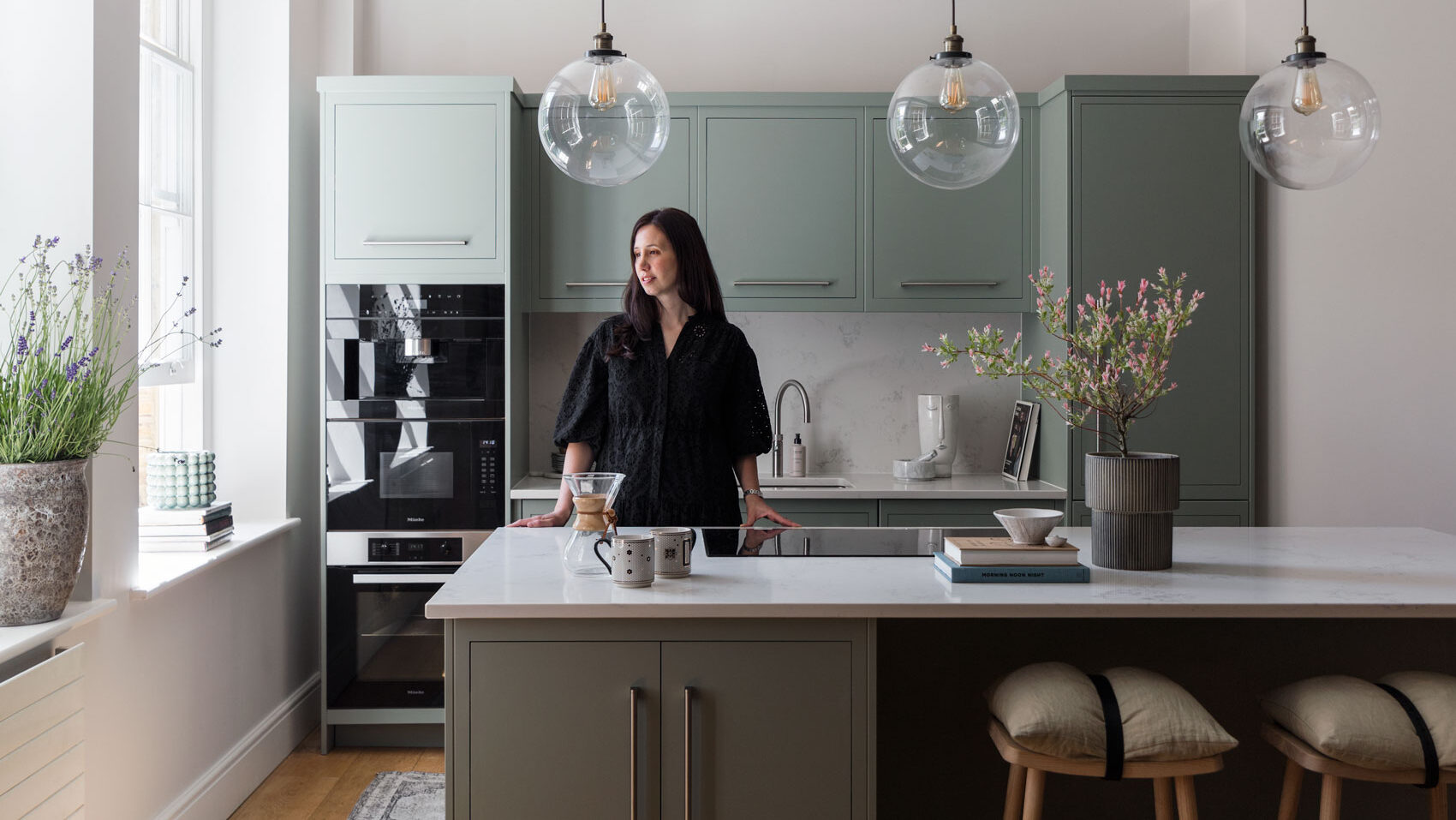 Light green modern kitchen with integrated double oven stack