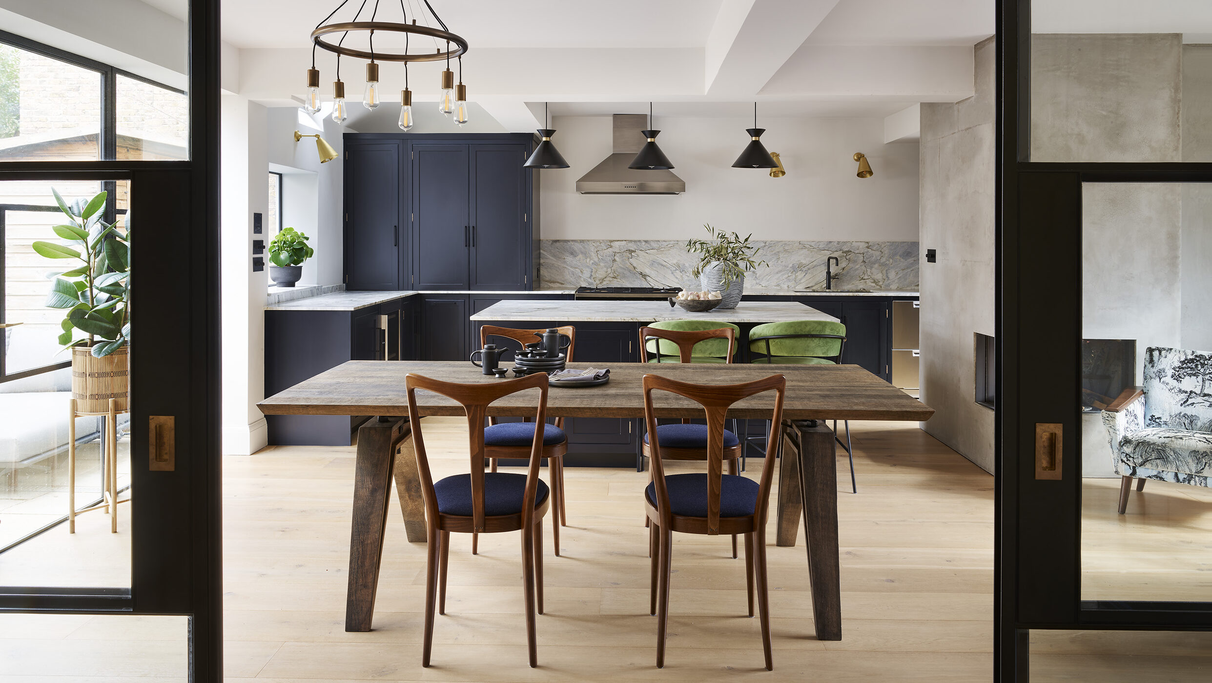 Luxury kitchen diner with navy cabinetry and wood accents