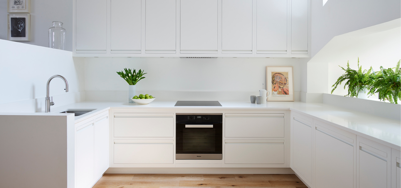 Sleek white luxury kitchen with integrated oven