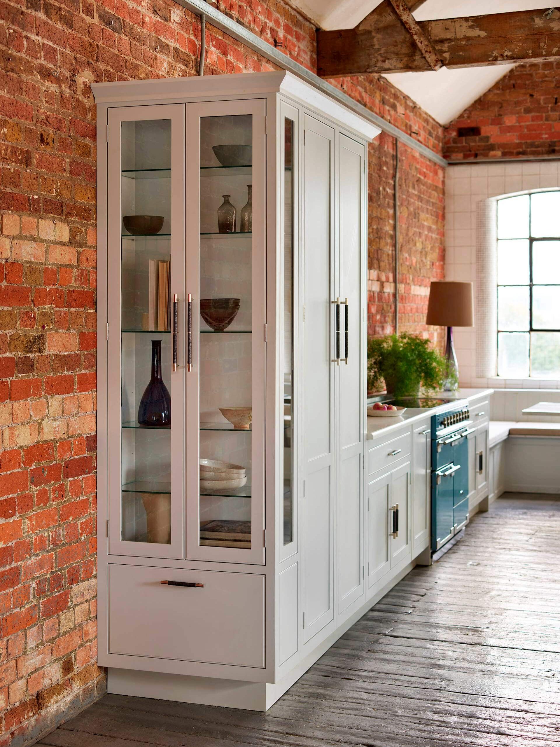 Integrated kitchen storage cupboard with glass doors in an industrial kitchen