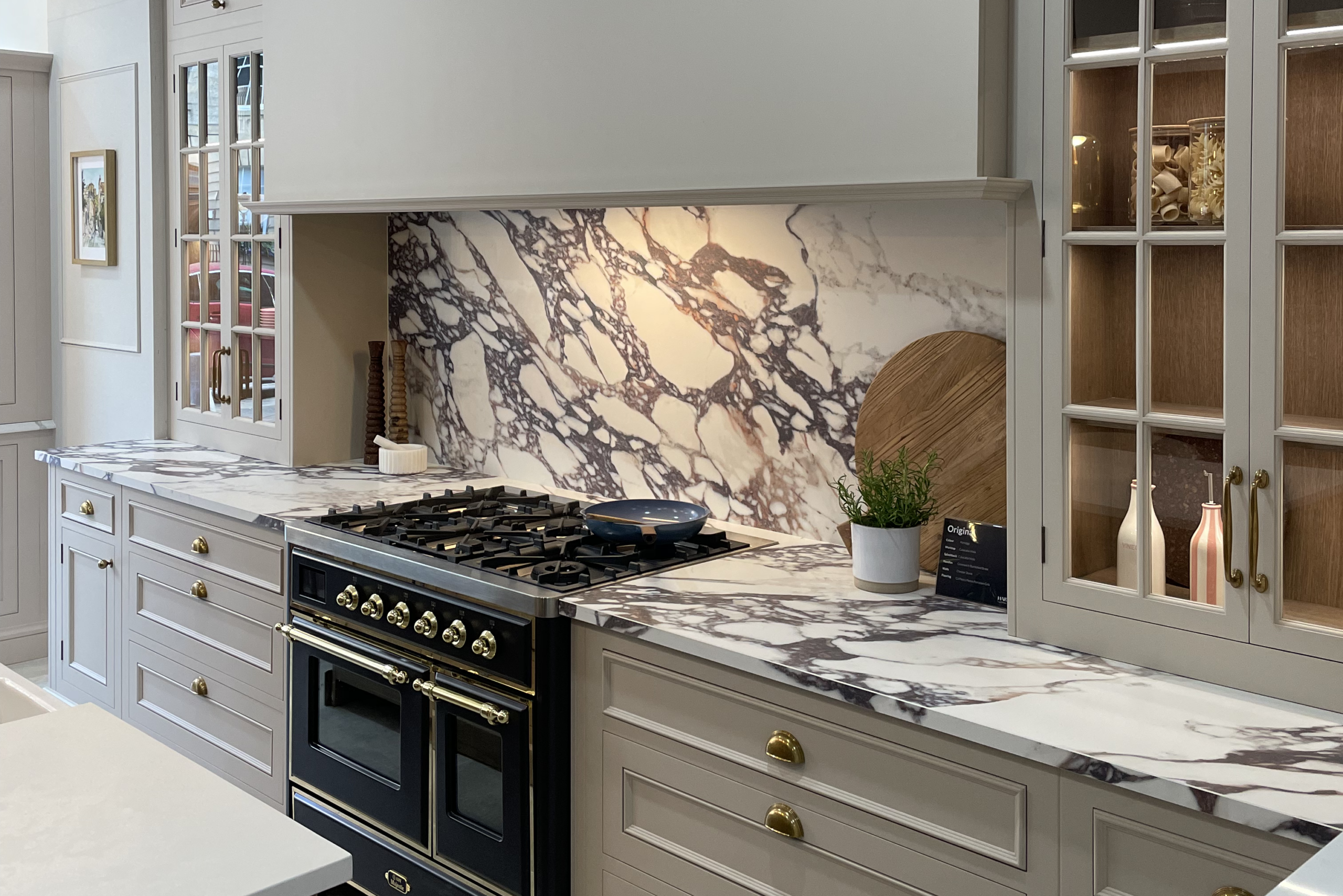 Modern kitchen with statement marble backsplash and worktops and bespoke  cabinetry