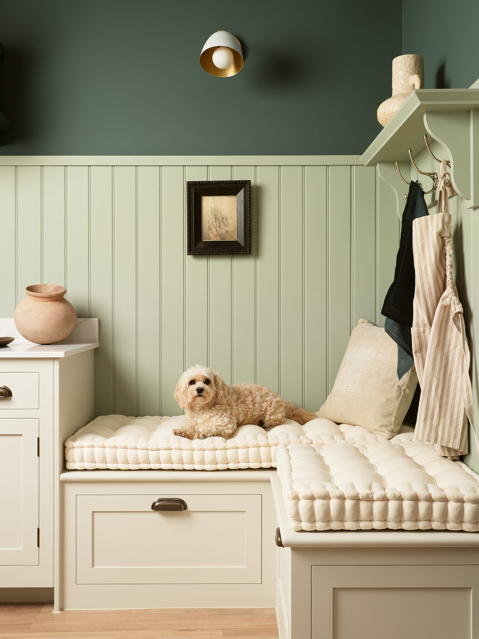 Green utility boot room with bench seating and bespoke cabinetry