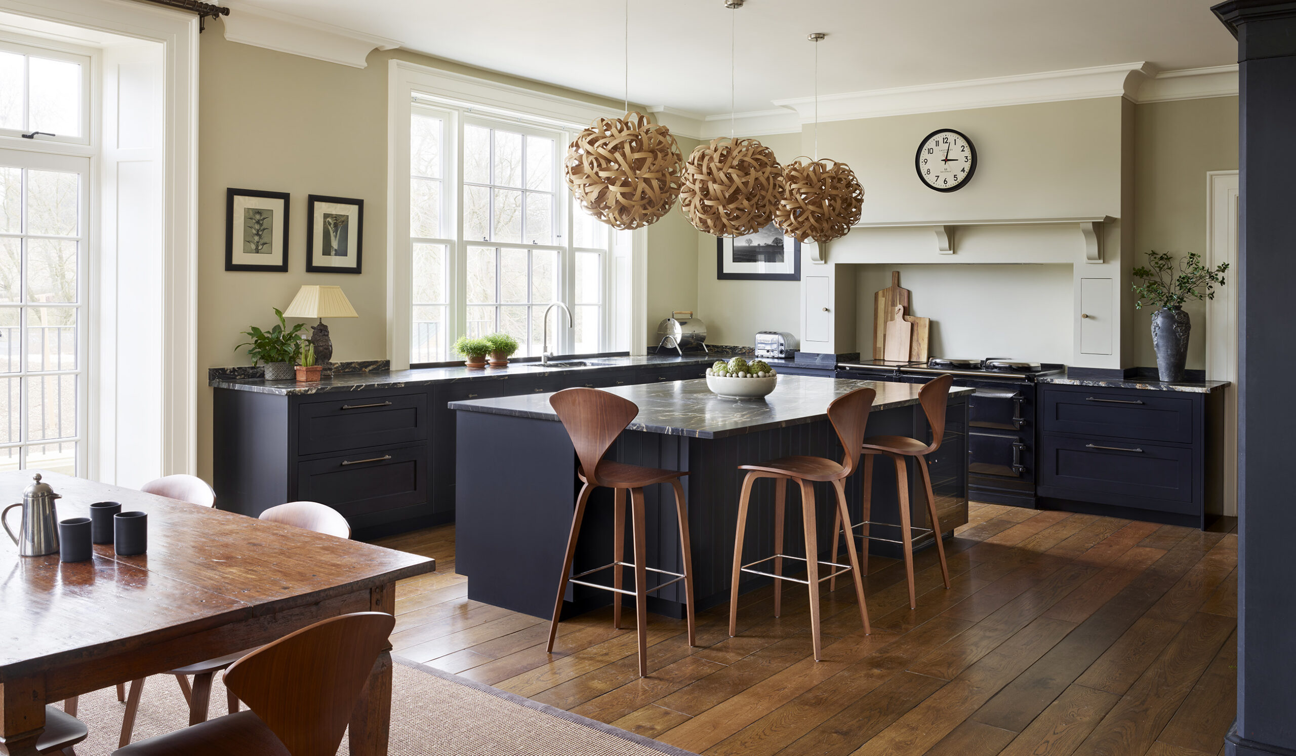 Navy blue kitchen with dark wood accents and bespoke overmantle cooker hood