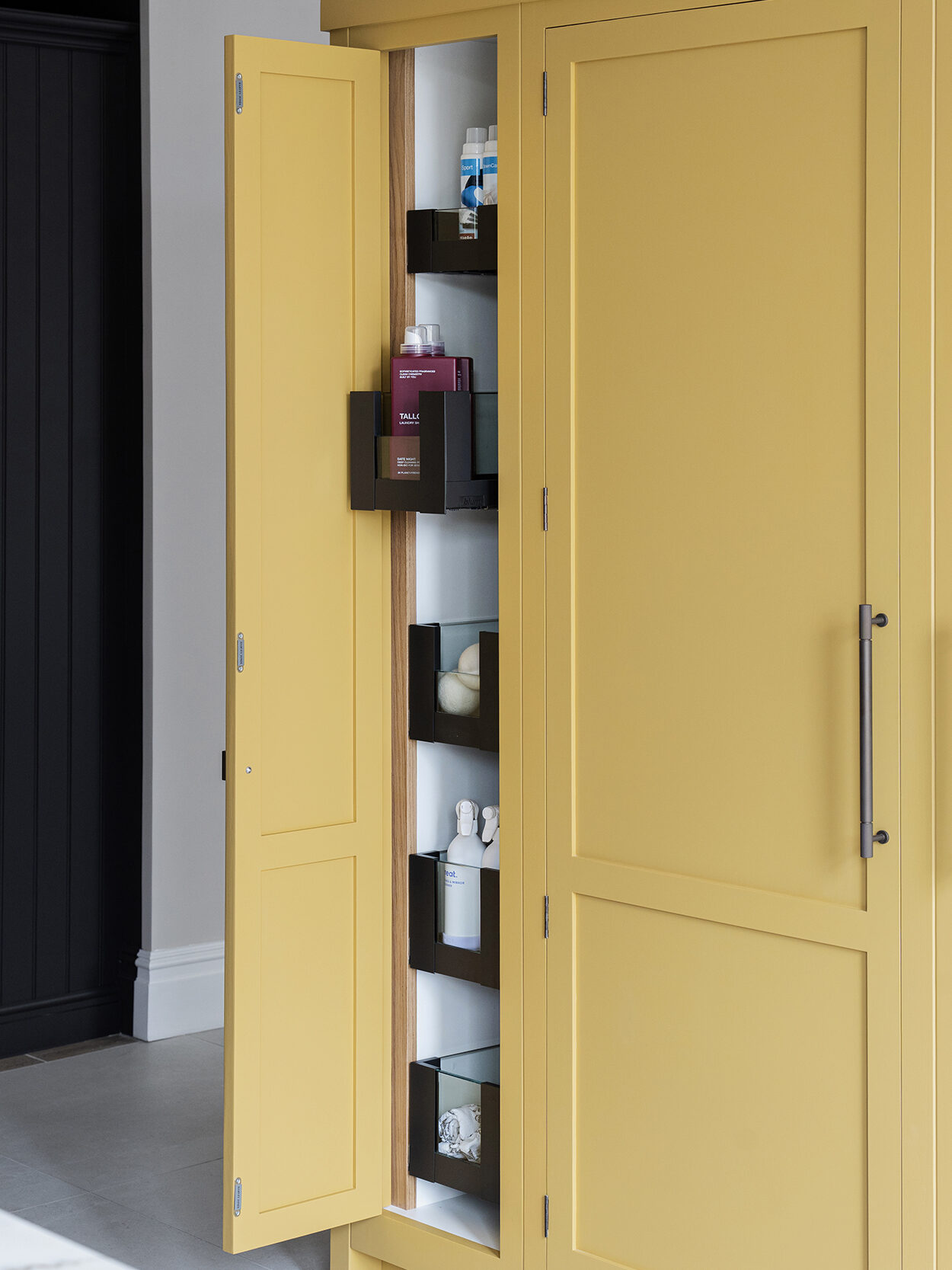 Yellow kitchen with hidden vertical storage drawers for narrow space