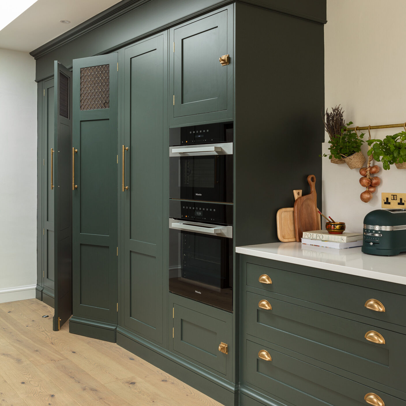 Dark green shaker kitchen with integrated ovens
