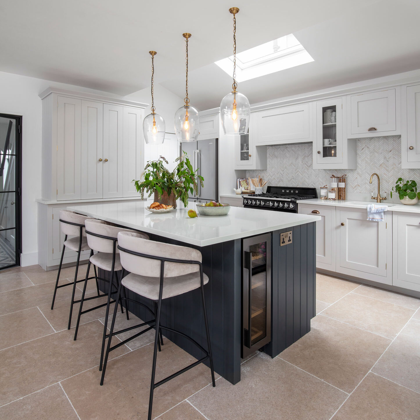 White and navy modern shaker kitchen with layered lighting island pendants and natural light