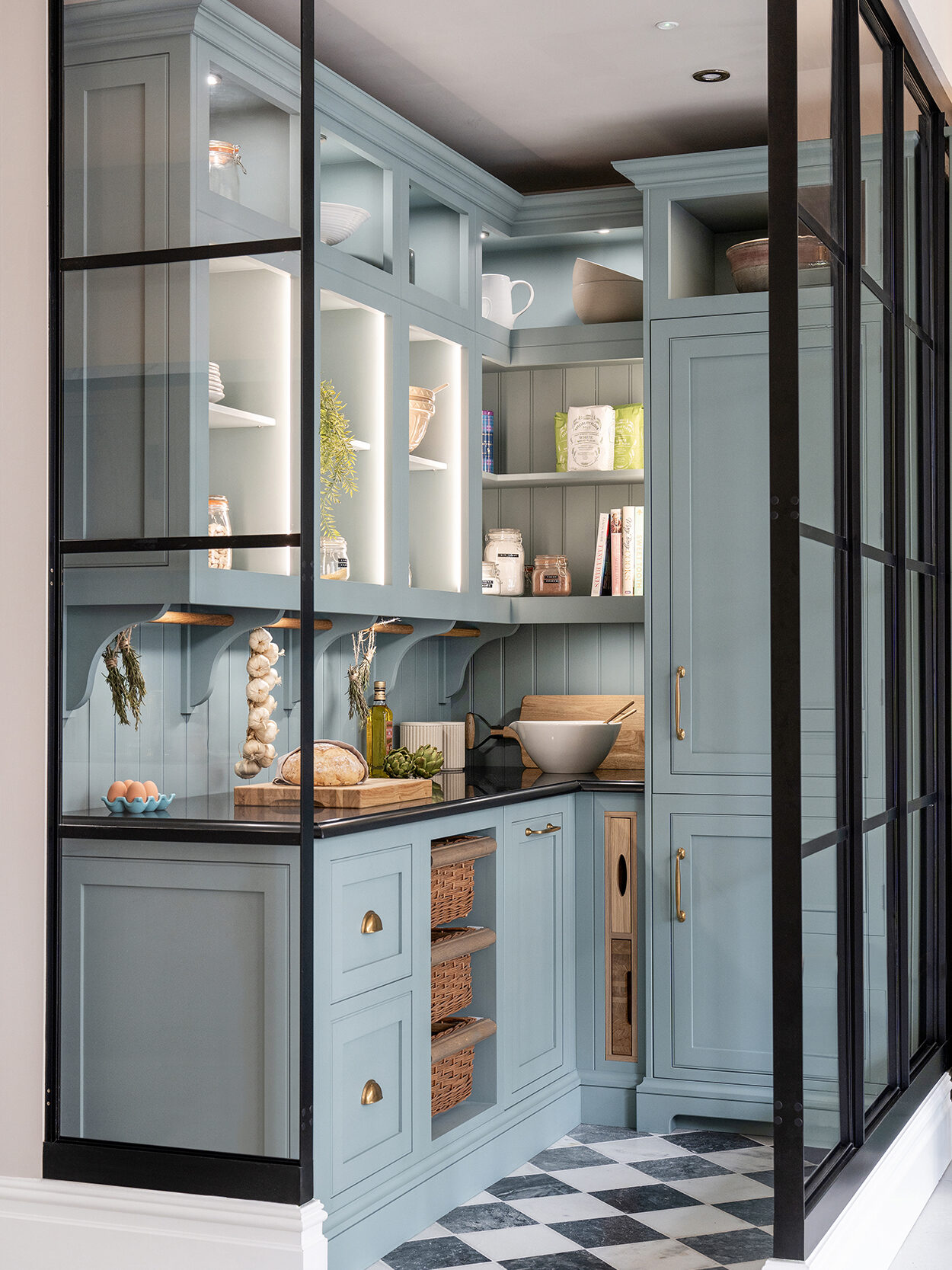 Blue walk in pantry with worktop space, integrated refrigeration, open shelving and drawers