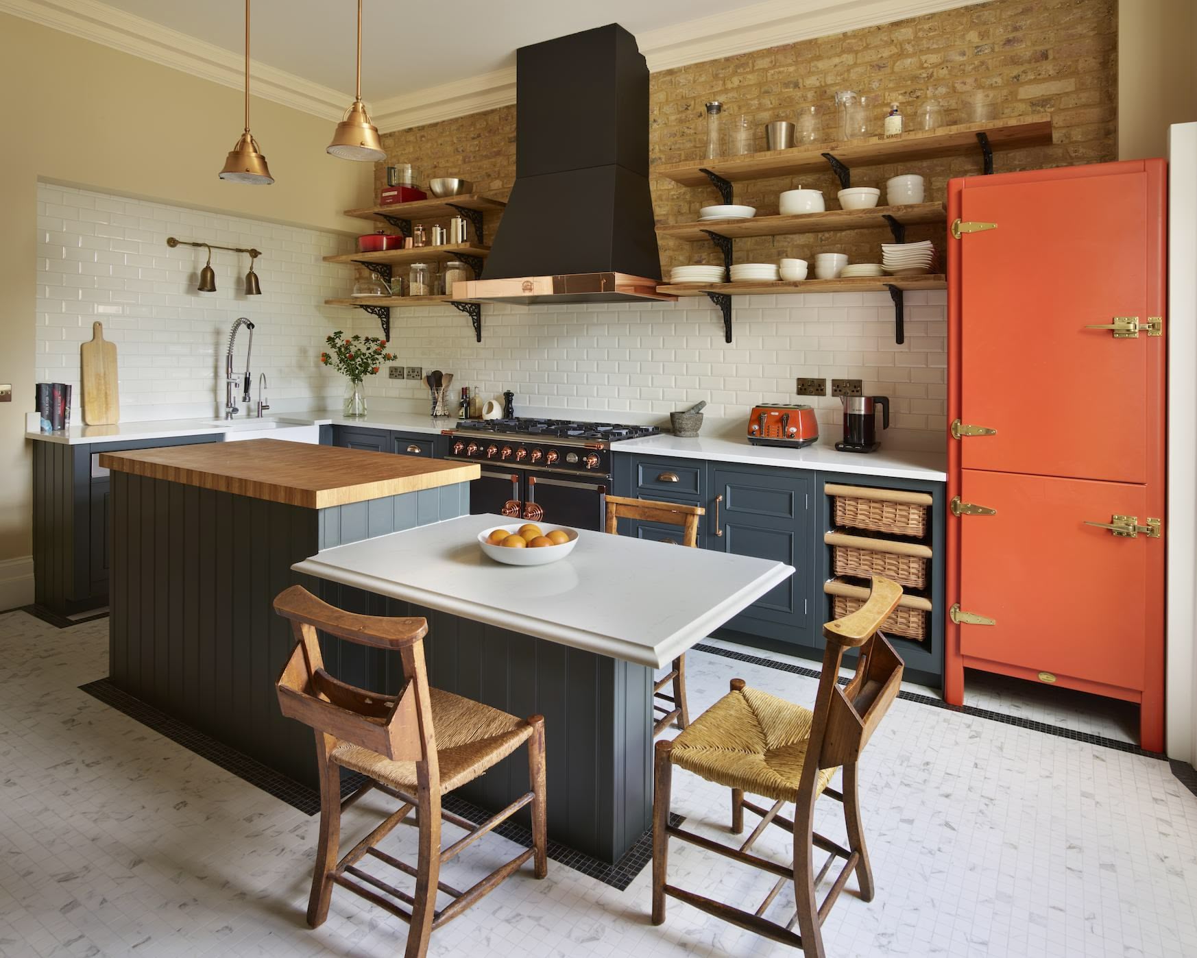 Navy blue farmhouse kitchen with copper accents, open shelving and exposed brickwork