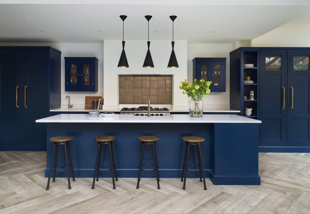 navy blue kitchen with white worktop and warm natural textures