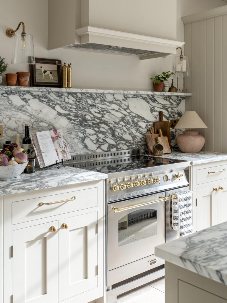 Modern farmhouse style kitchen with marble countertop and splashback, rangecooker and shaker style cabinetry