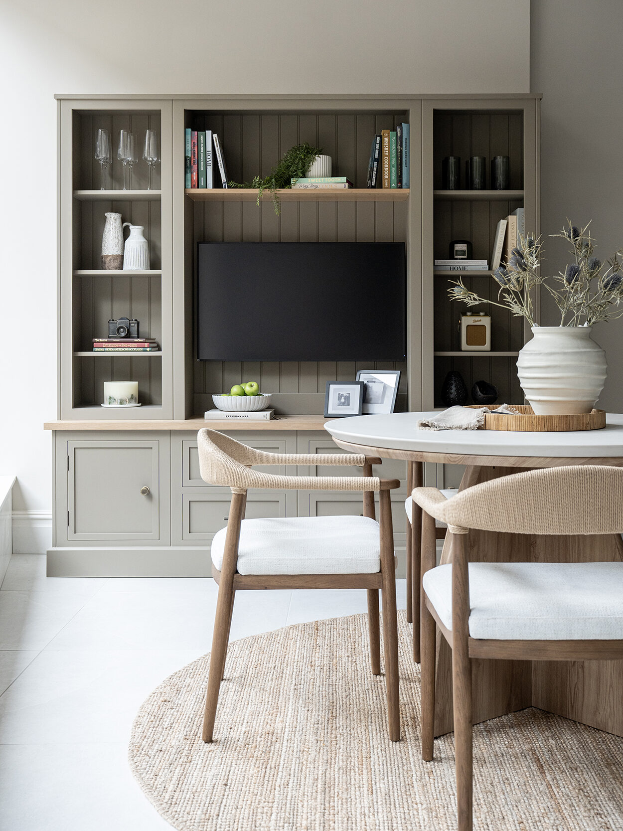Taupe media wall in home office with integrated TV and Shaker style cabinetry
