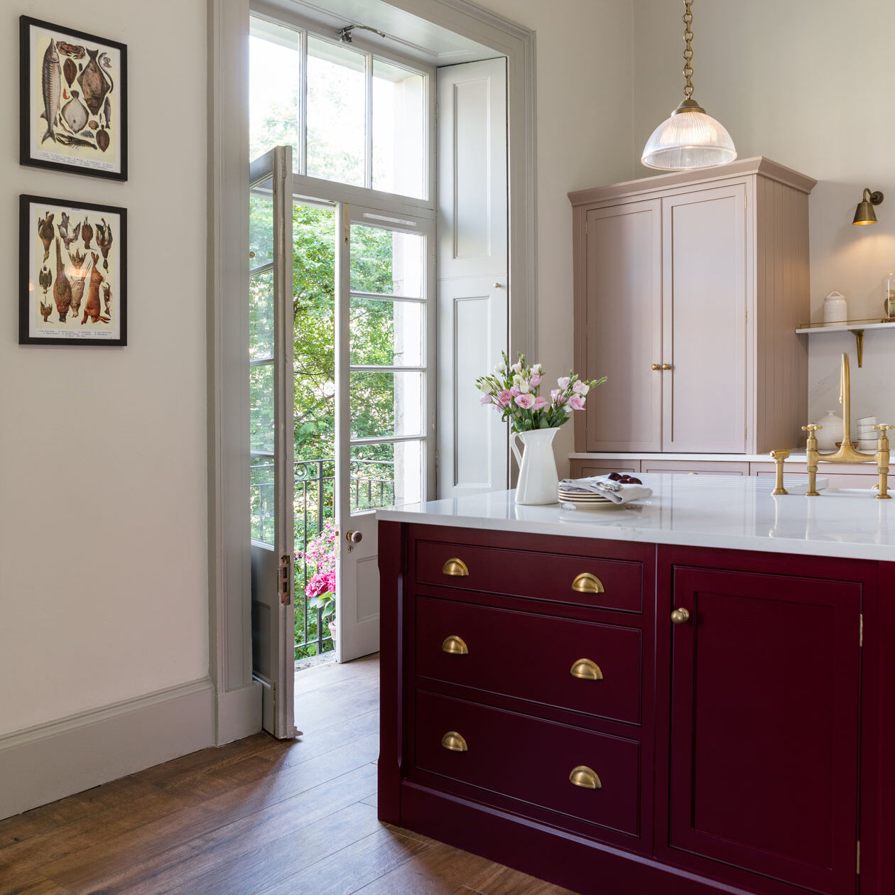 Burgundy kitchen island with pink kitchen cabinetry and tall balcony doors