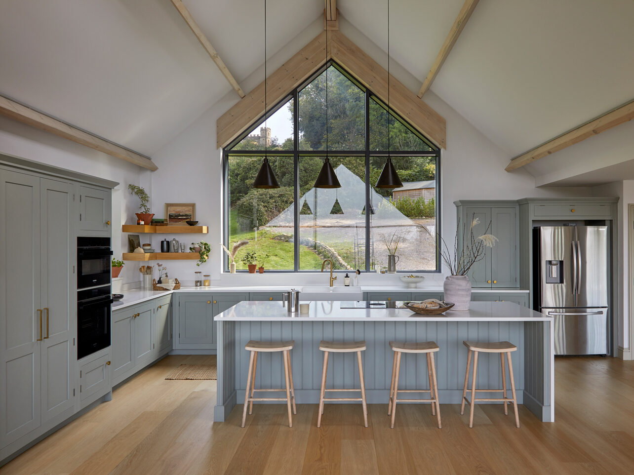 Light blue Shaker kitchen with L shaped layout in open plan design