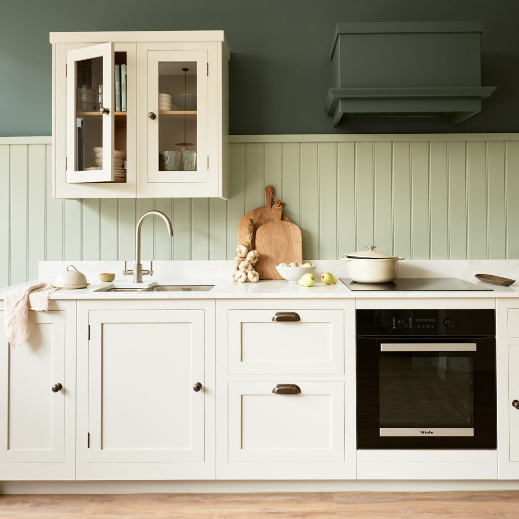 Neutral kitchen with green panelling and dark green colour capping in a small kitchen