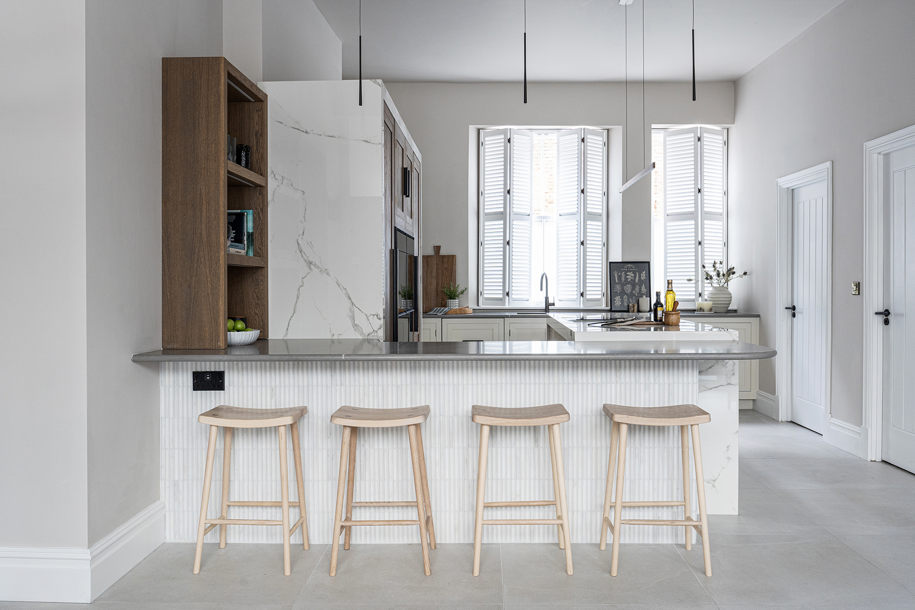 Scandi style kitchen with marble, white and wood palette and kitchen peninsula with seating