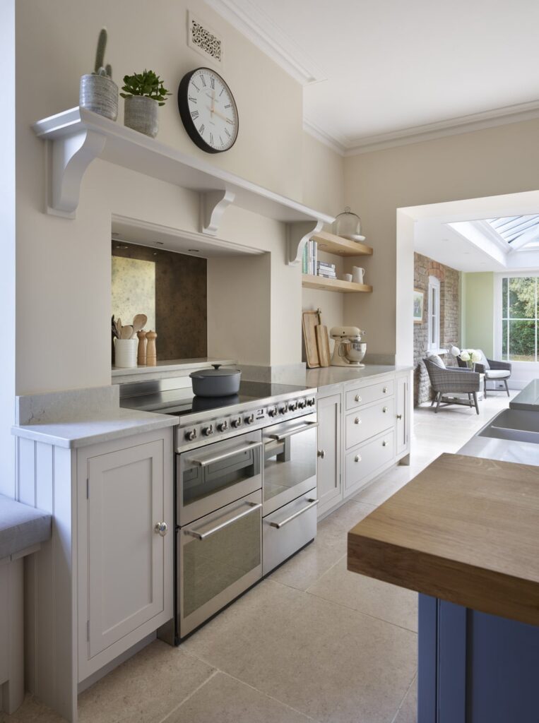 Neutral orangery kitchen with hidden mantel extractor and traditional kitchen features with range cooker