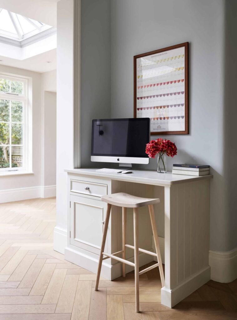 Small home office desk nook with desk and storage space painted in neutral cream