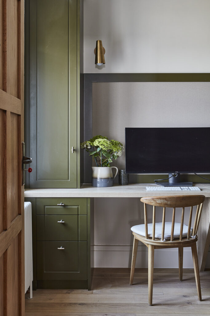 Olive green home office desk nook with built in storage, lighting and desk