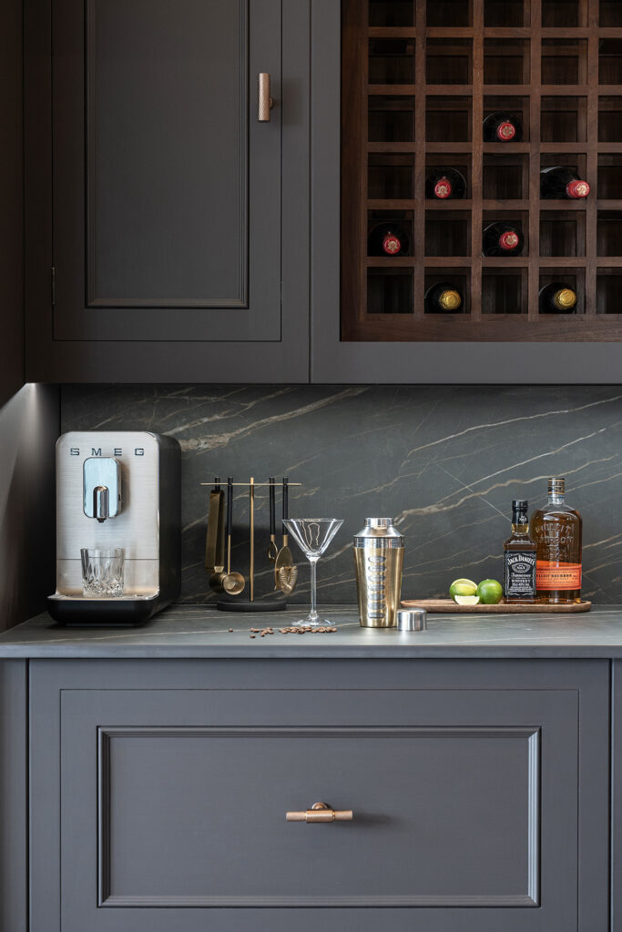 Moody home bar nook with bespoke kitchen cabinetry painted in deep black blue with wine storage and cocktail storage
