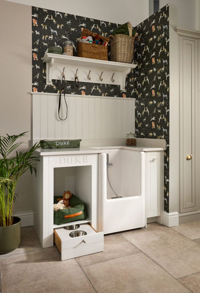 Pet zone in a kitchen with dog bath and pull out food and water bowls featuring hooks for leads and tongue and groove backsplash
