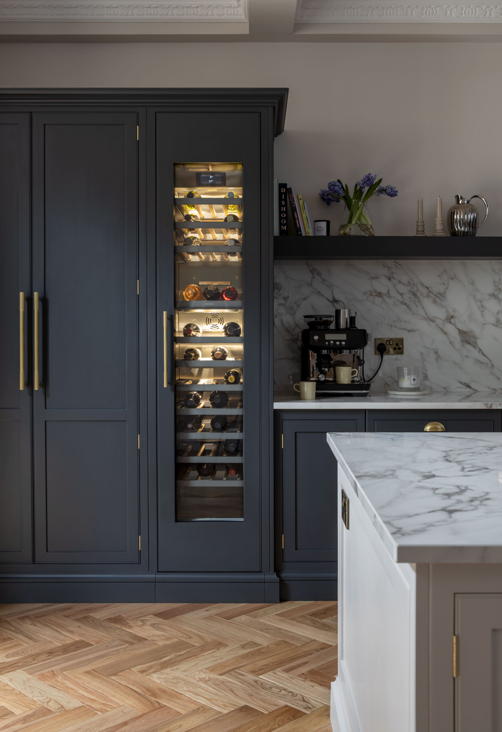 Navy blue luxury kitchen with wine fridge featuring ambient lighting
