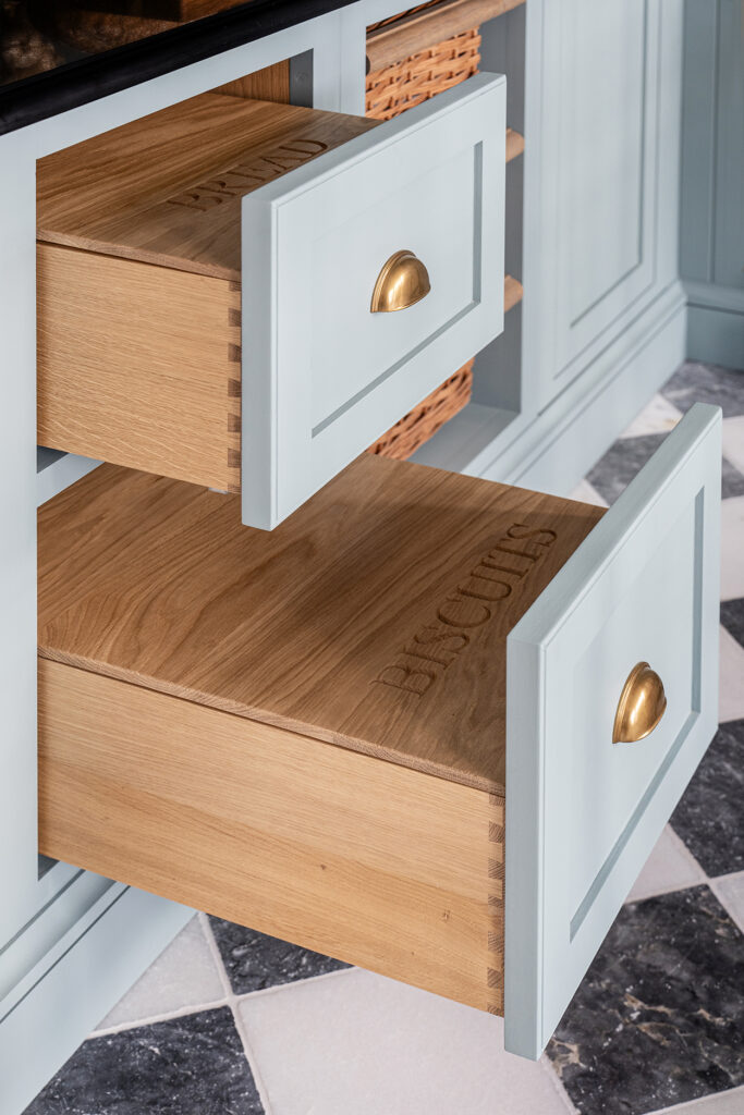 Blue walk in pantry with bespoke wooden drawer storage for bread and biscuits