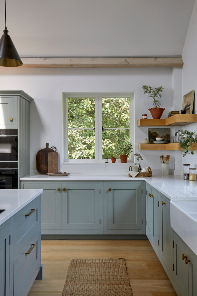 Light blue green shaker kitchen with wooden flooring, in frame construction and island