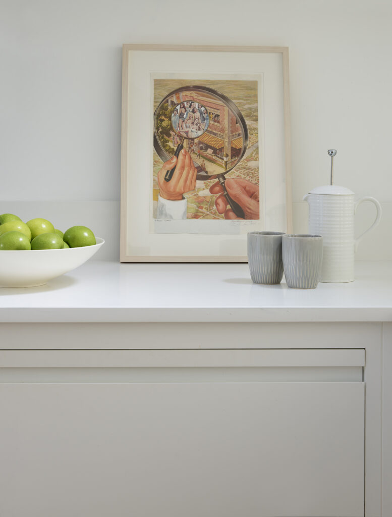 White handleless kitchen with artwork and ceramics and in frame design