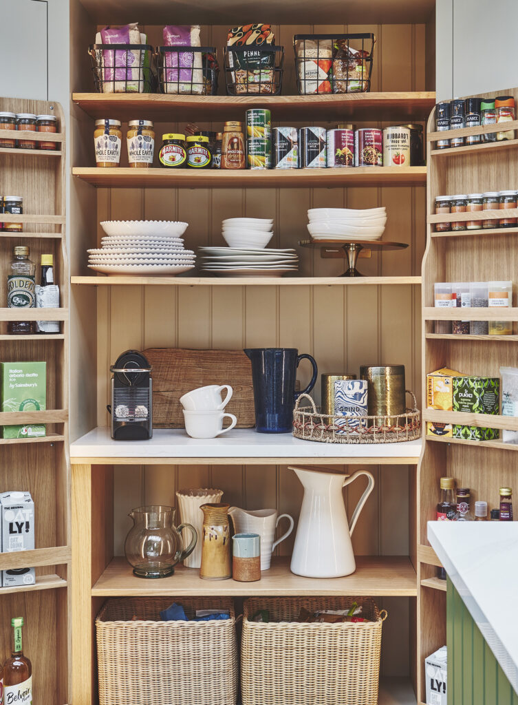 Light orange painted pantry with open shelving and built-in door storage racks
