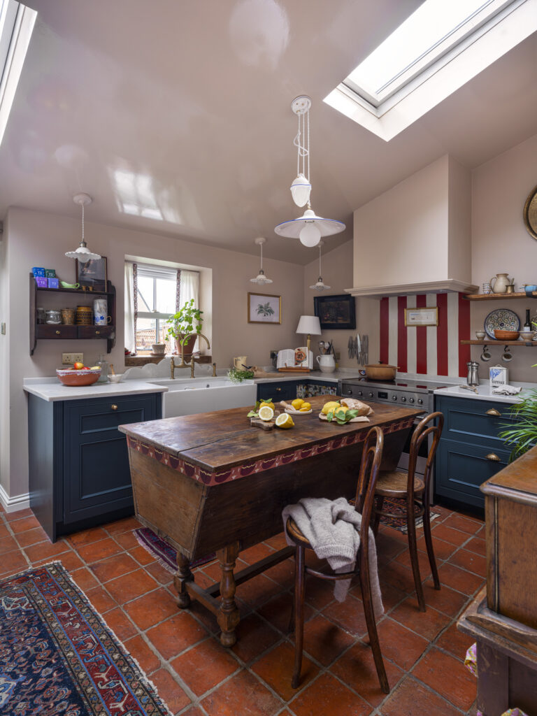 After a kitchen renovation, eclectic kitchen design with traditional cabinetry, maximalist styling, quartz worktops and dark green cabinetry