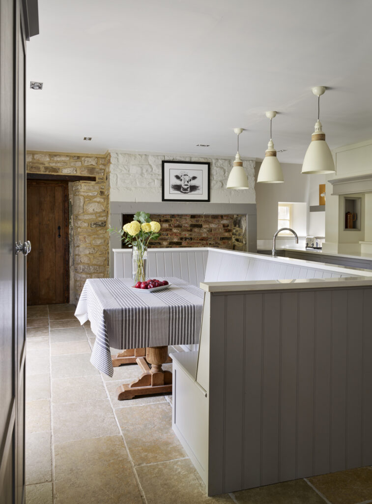 Kitchen diner with U shaped bench seating island zone painted in greige shade