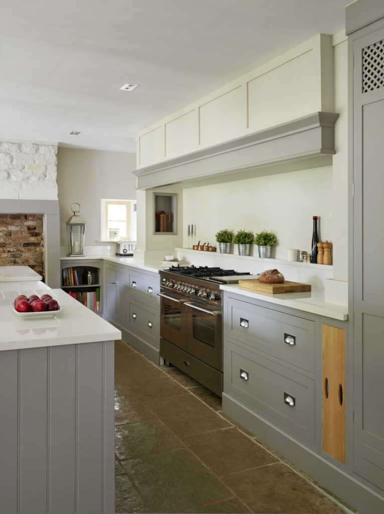Farmhouse kitchen cooking area with built in extractor, range cooker and greige cabinetry with built in features