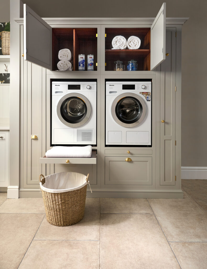 Utility room display in Harvey Jones kitchen showroom, with side by side washer dryer, built in shelves and maximised storage