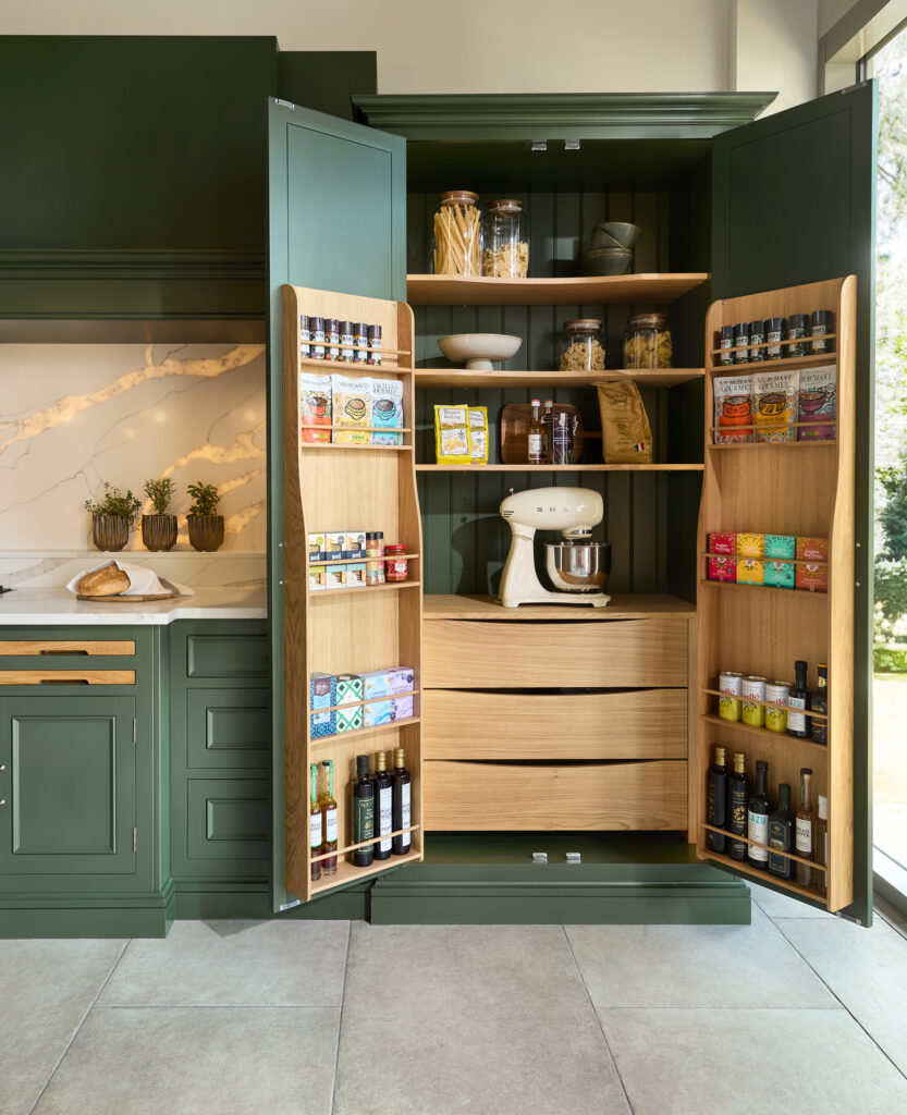 Green kitchen display with double door pantry cupboard storing dried good, appliances and internal solid wood drawers