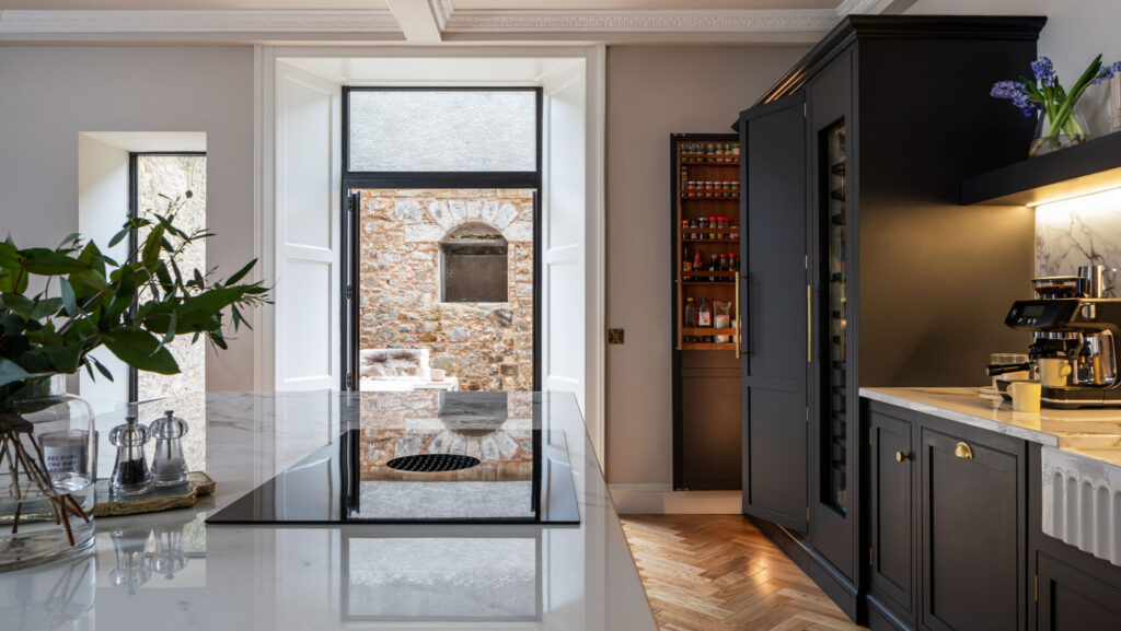 Integrated Butler's pantry in a bespoke handmade kitchen painted in navy blue with white quartz worktops and herringbone flooring