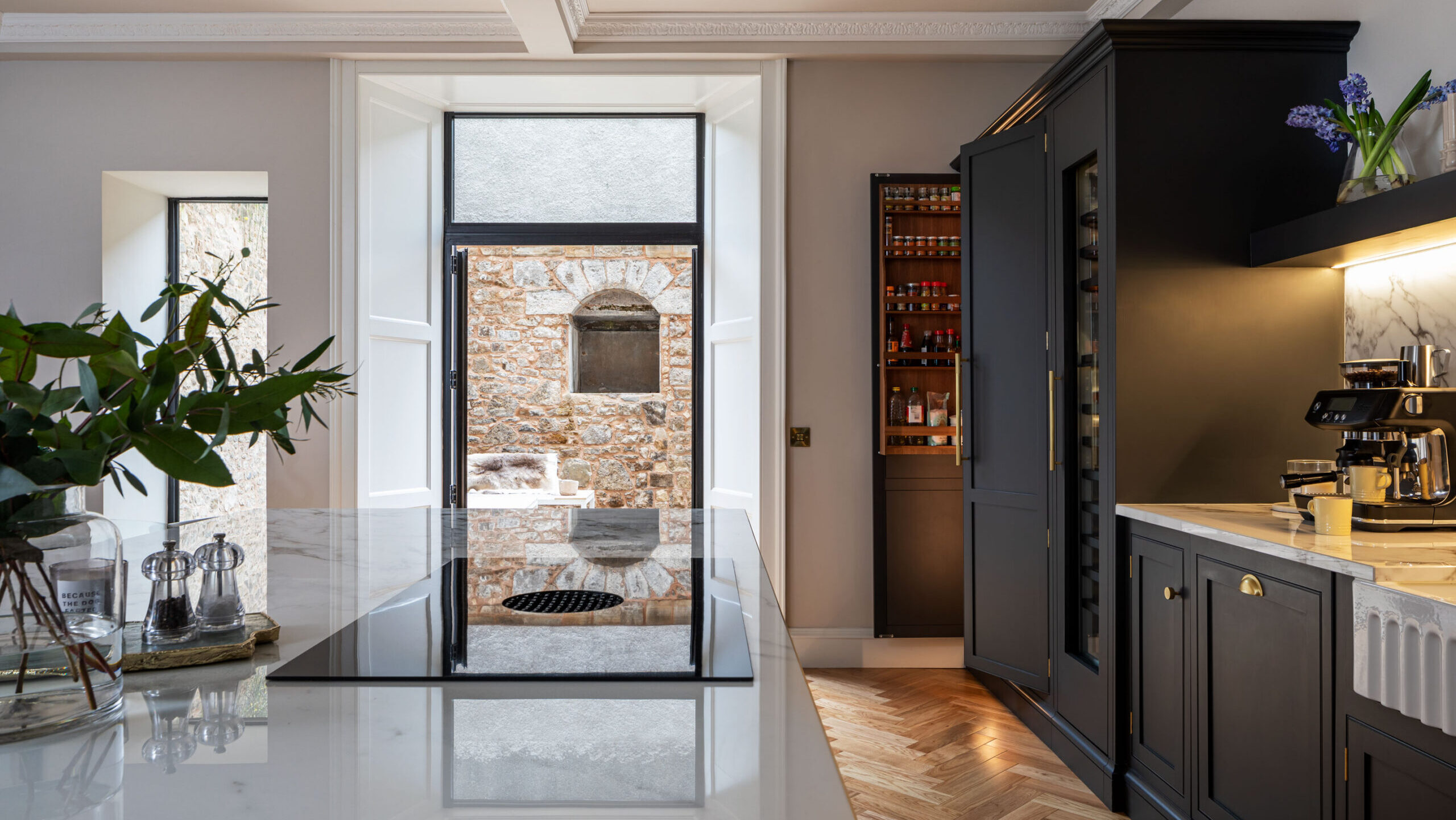 Integrated Butler's pantry in a bespoke handmade kitchen painted in navy blue with white quartz worktops and herringbone flooring